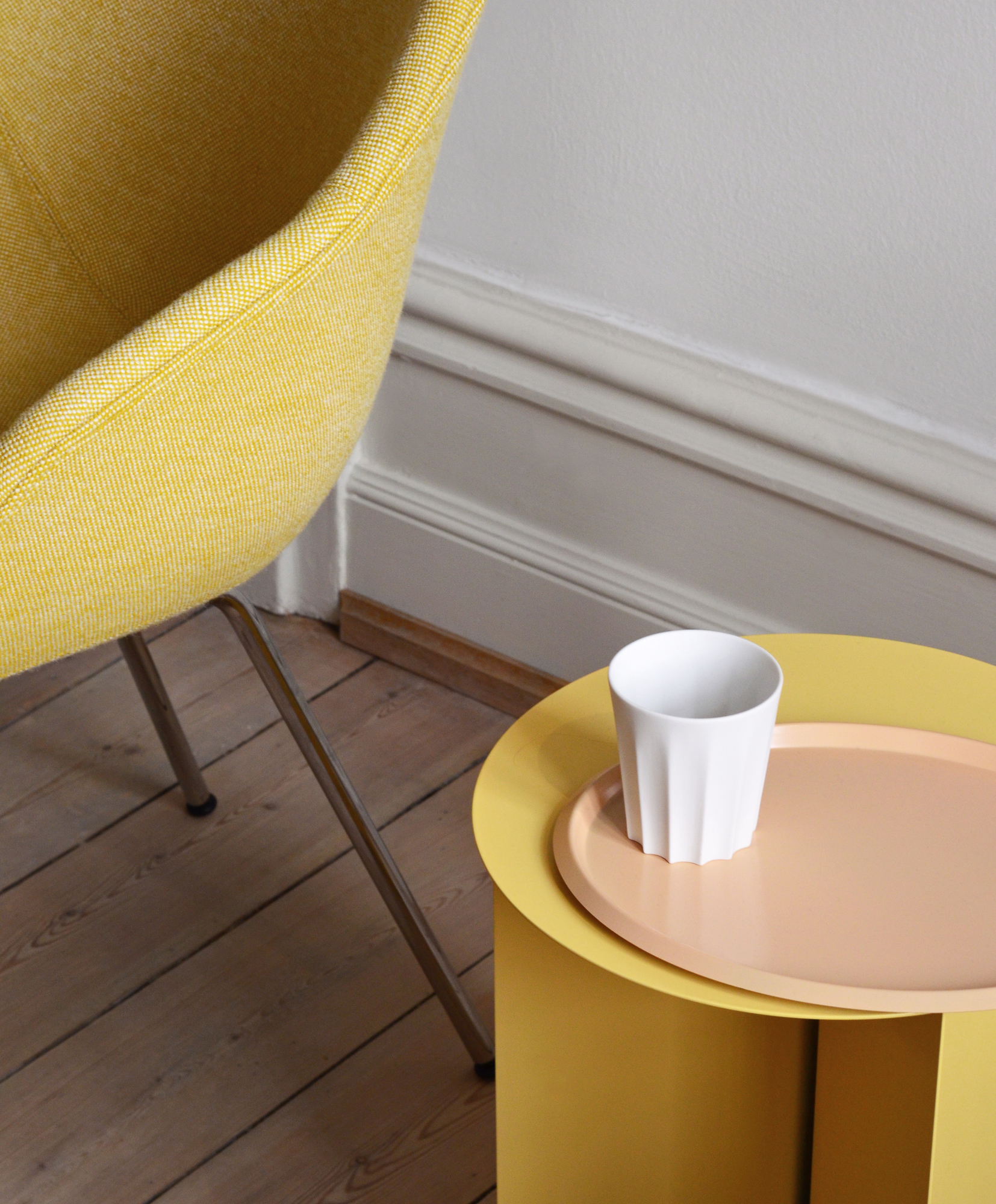 Detailaufnahme vom gelben Hay About a Chair AAC127 Stuhl neben einem gelben Beistelltisch mit Tasse.