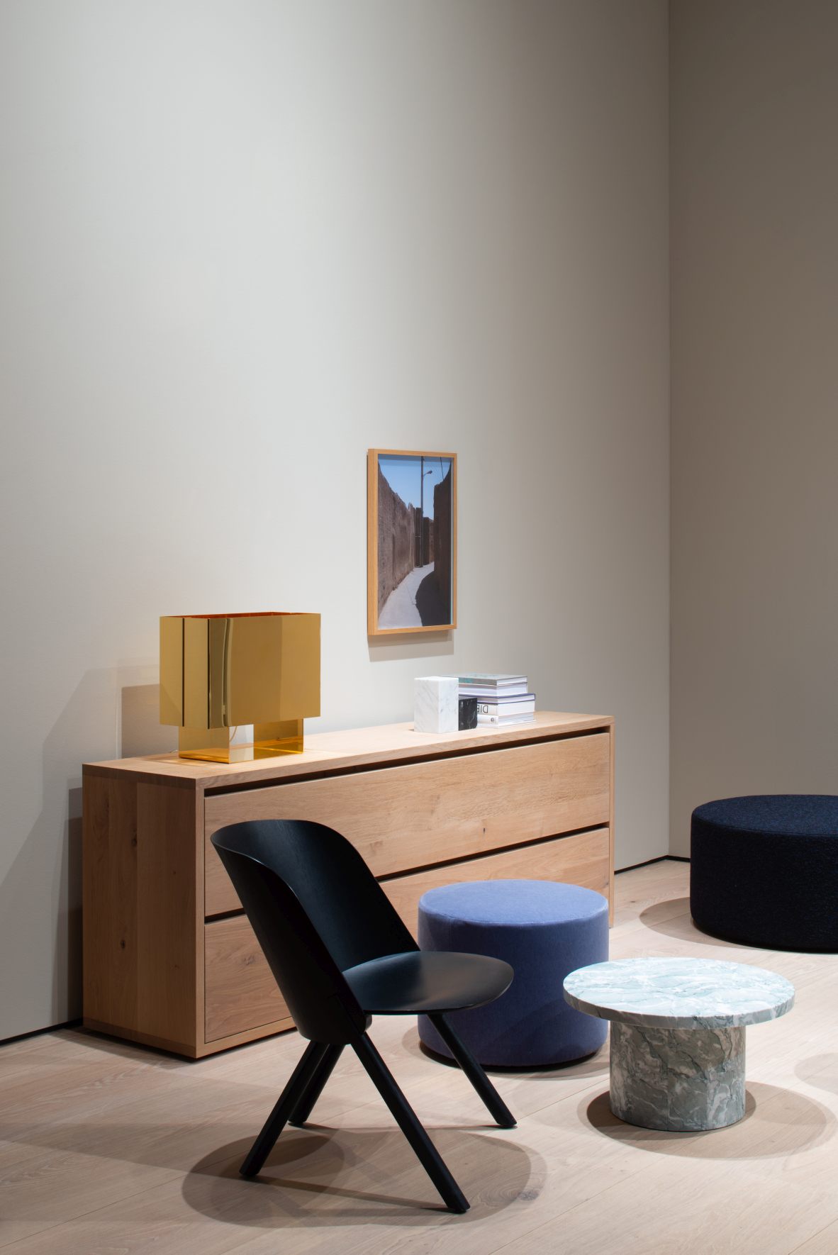 Schwarzer EC05 That Sessel von e15 neben Kommode, Pouf und Marmortisch in modernem Wohnraum.