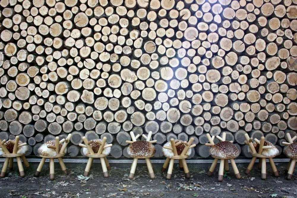 Bambi Kinderstuhl EO: Reihe von Kinderstühlen im Reh-Design vor einer Holzwand.