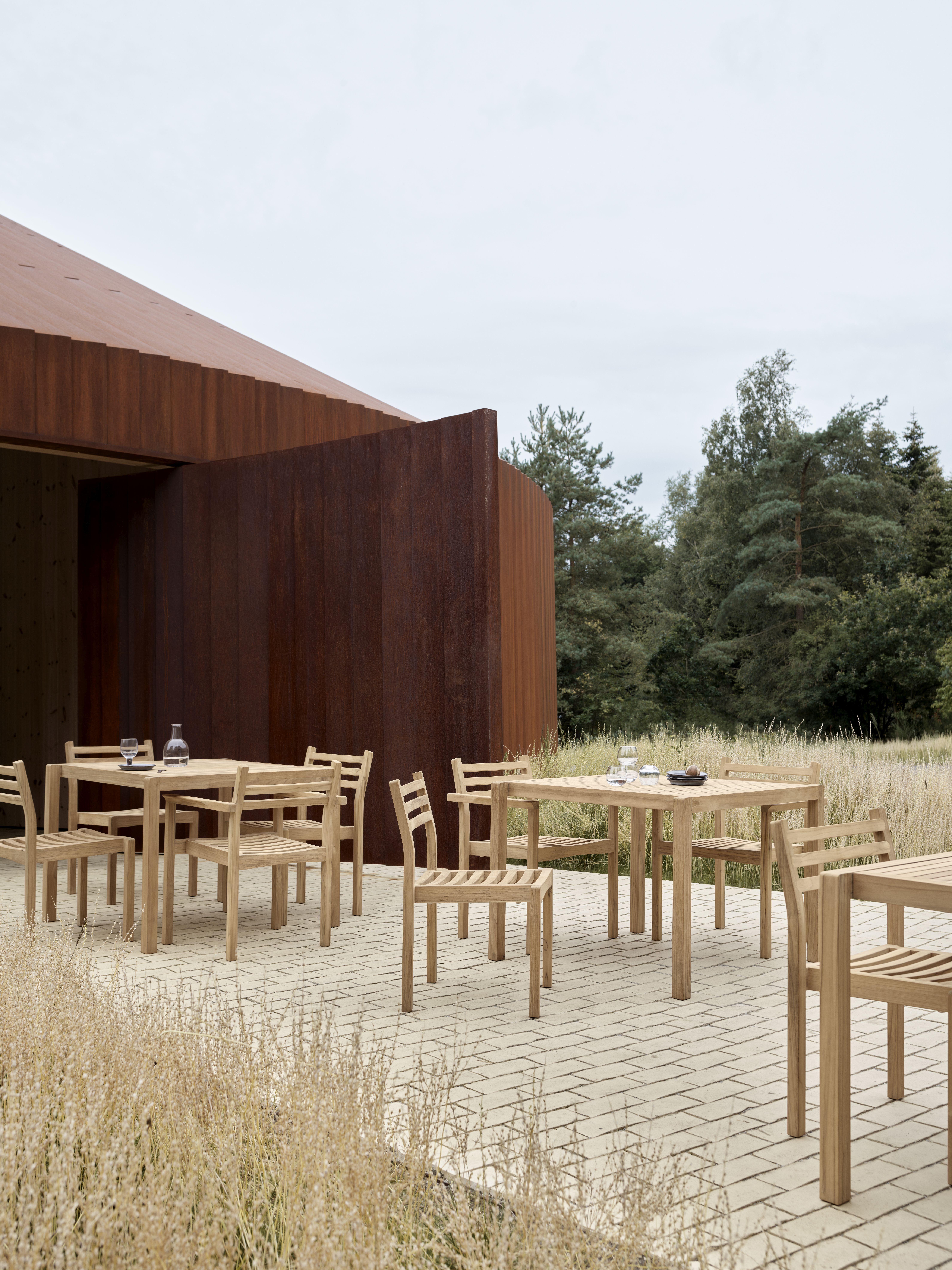 AH902 Esstisch Outdoor von Carl Hansen & Søn aus Holz mit Stühlen auf Terrasse.