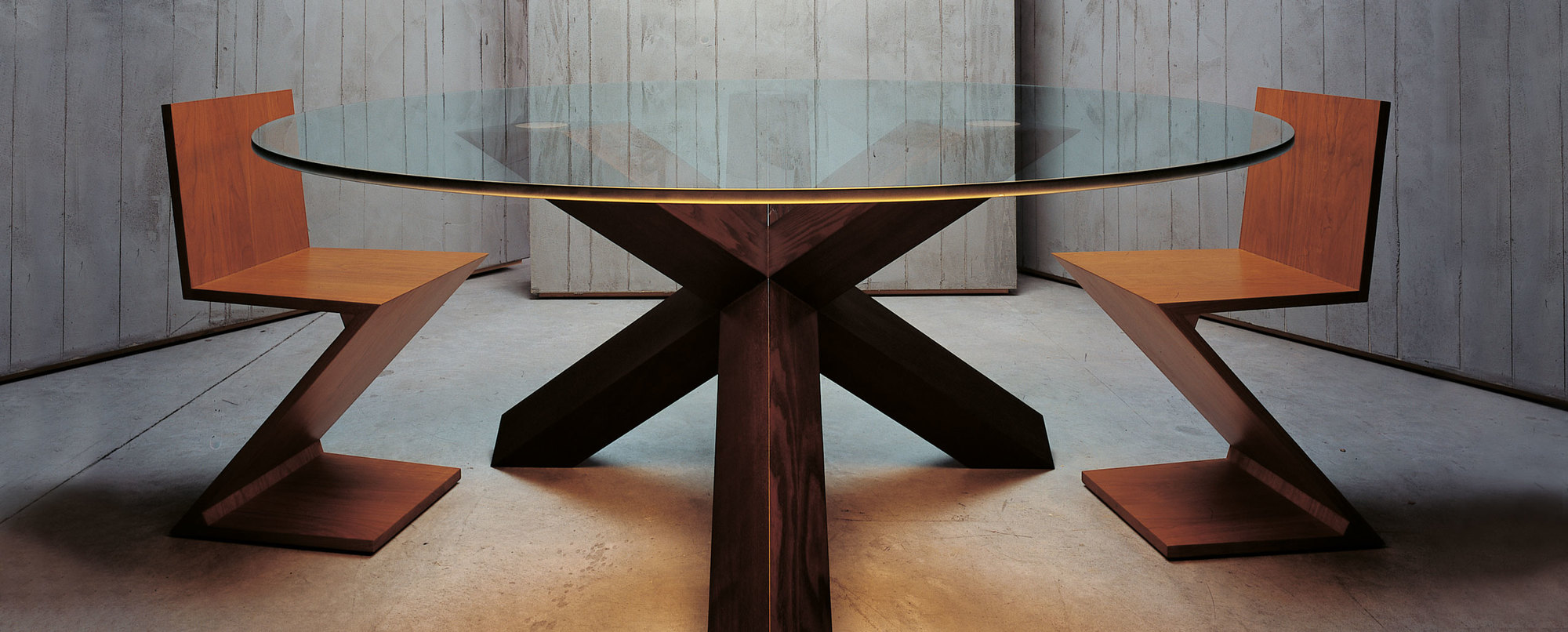 Zig-Zag Stuhl von Cassina aus Holz neben einem runden Esstisch mit Glasplatte.