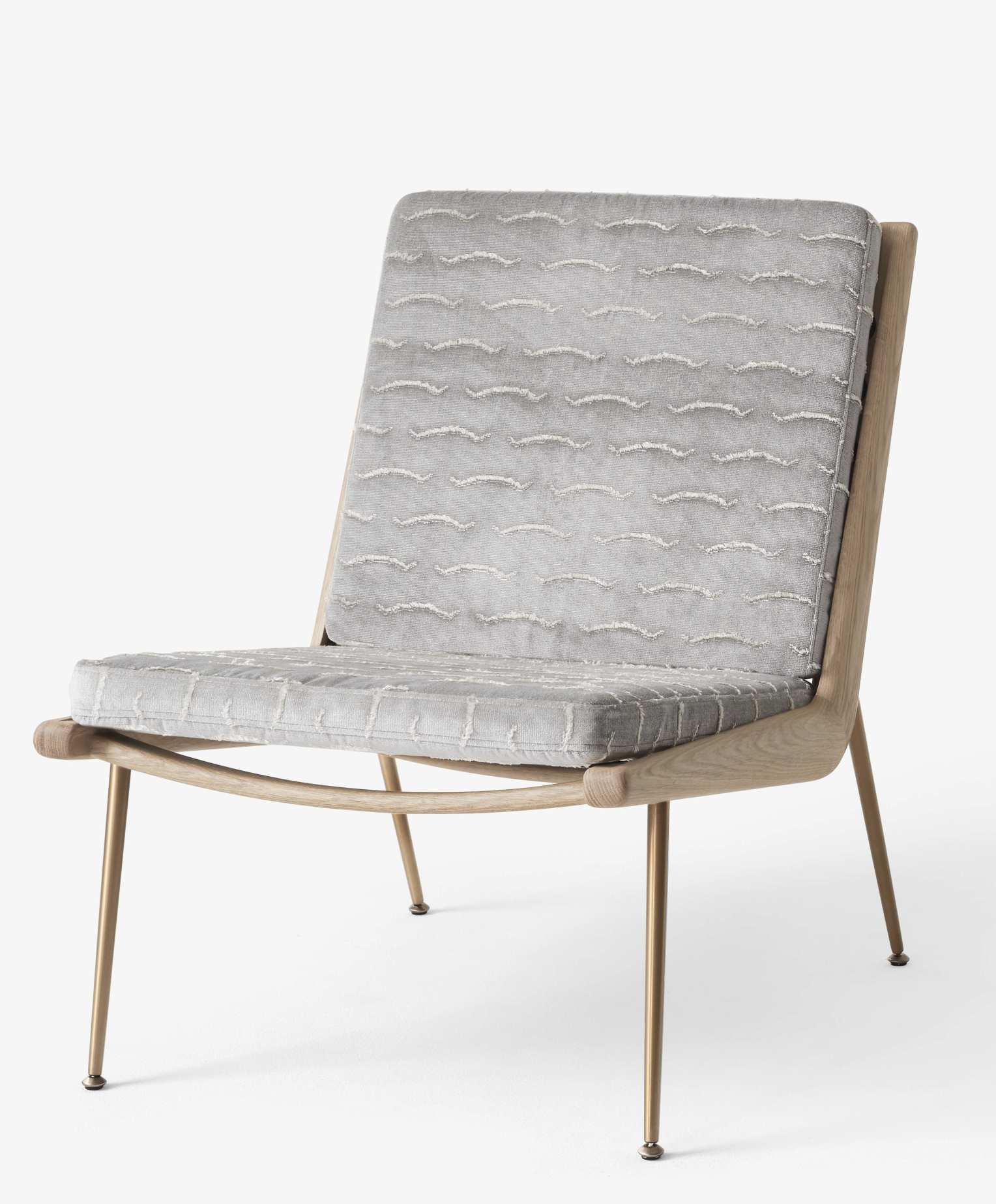 AndTradition Boomerang Sessel HM1 mit grauem Stoffbezug und hellem Holzgestell auf goldenen Beinen.
