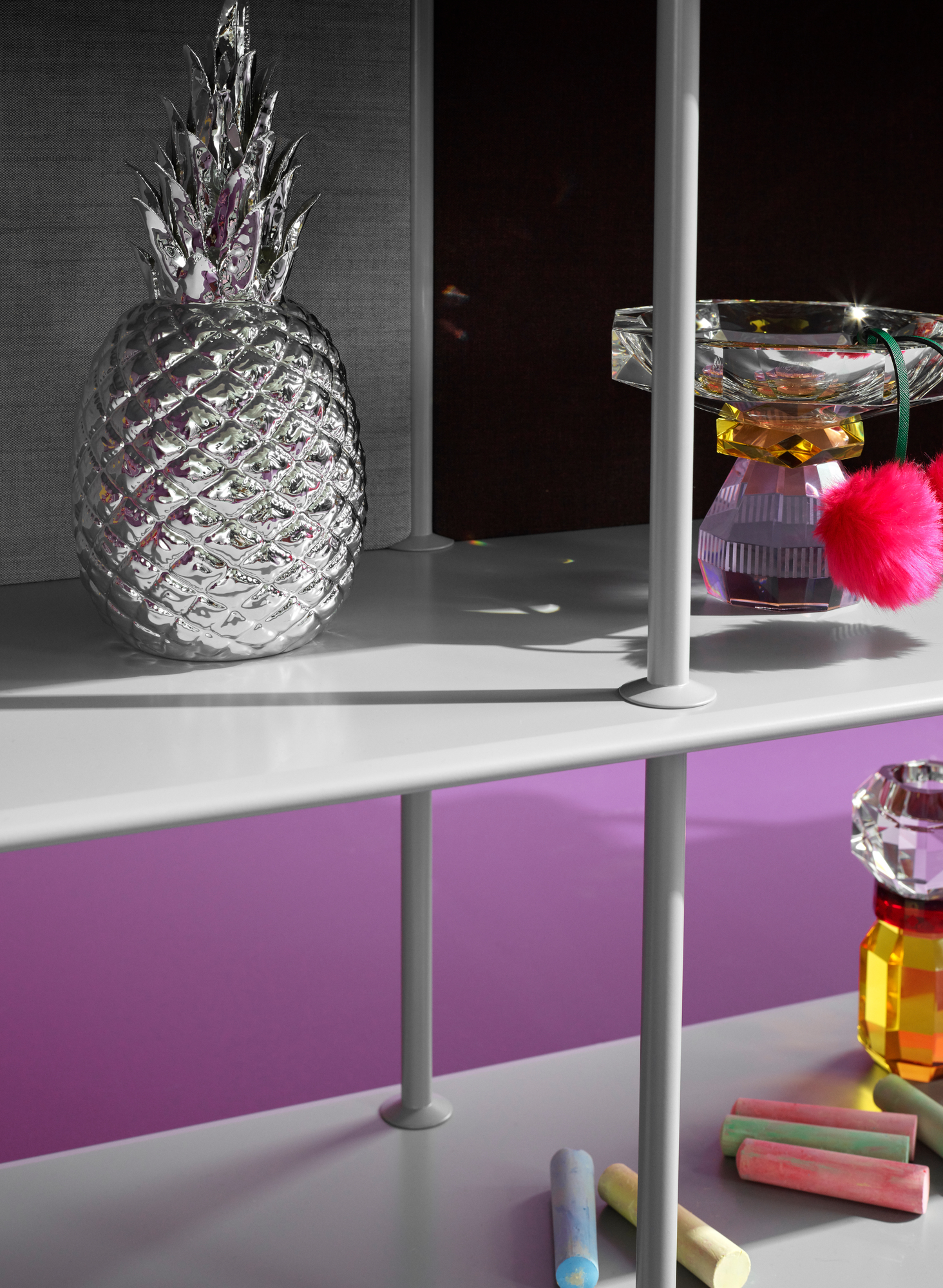 Montana Free Regal mit Deko-Elementen: Silberne Ananas, Glasobjekte und bunte Kreide. Modernes Regalsystem für Wohnraum und Büro.