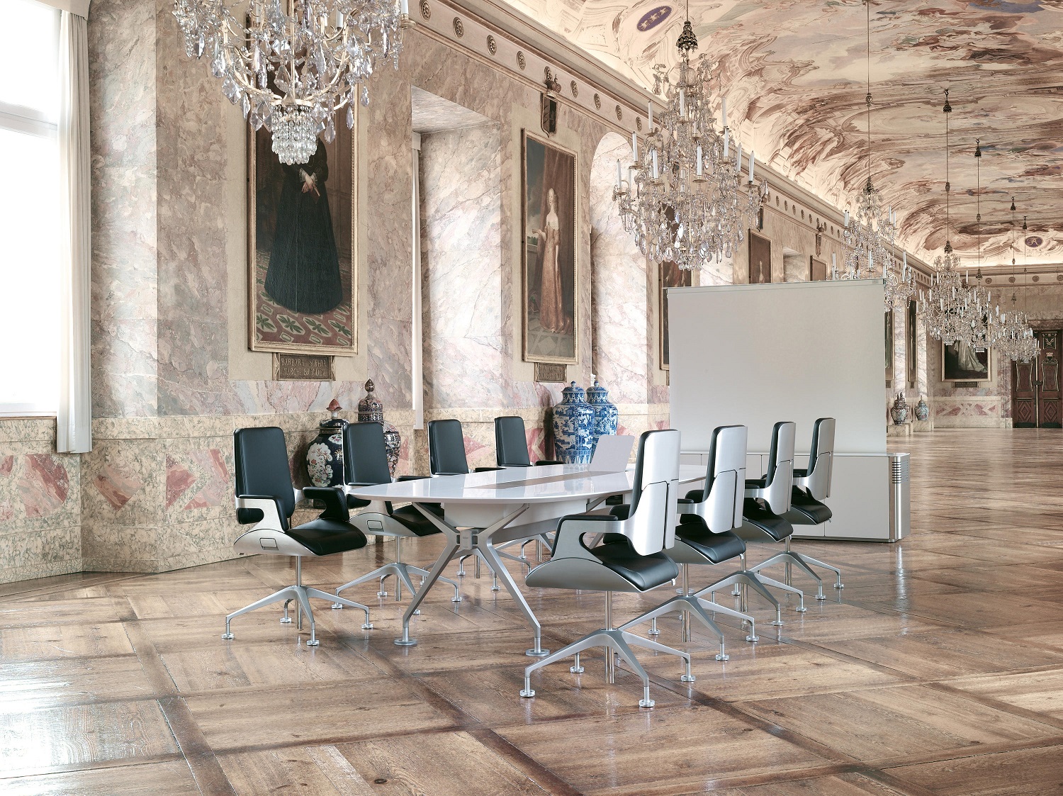 Silver 151S Interstuhl Konferenzsessel in stilvollem Konferenzraum mit weißem Tisch und Kronleuchtern.
