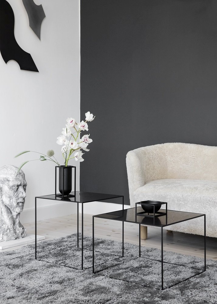 Helles Wohnzimmer mit Audo Mingle Sofa, schwarzen Couchtischen, Blumenvase und grauer Teppich für gemütliches Wohnen.