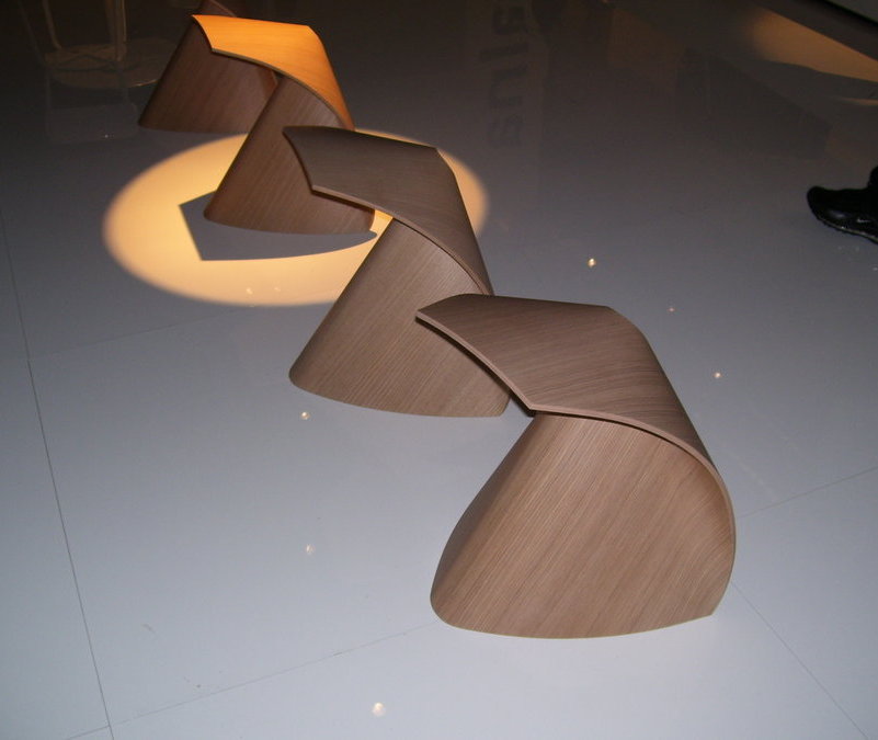 Drei moderne, hellbraune Holzstühle in Spiralform, minimalistisches Design für Wohnzimmer und Büro.