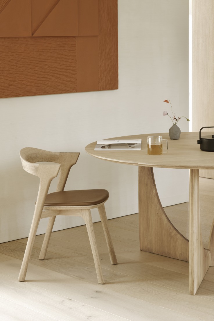 Ethnicraft Geometric Dining Table aus Eiche mit Stuhl und Deko auf Holzboden.