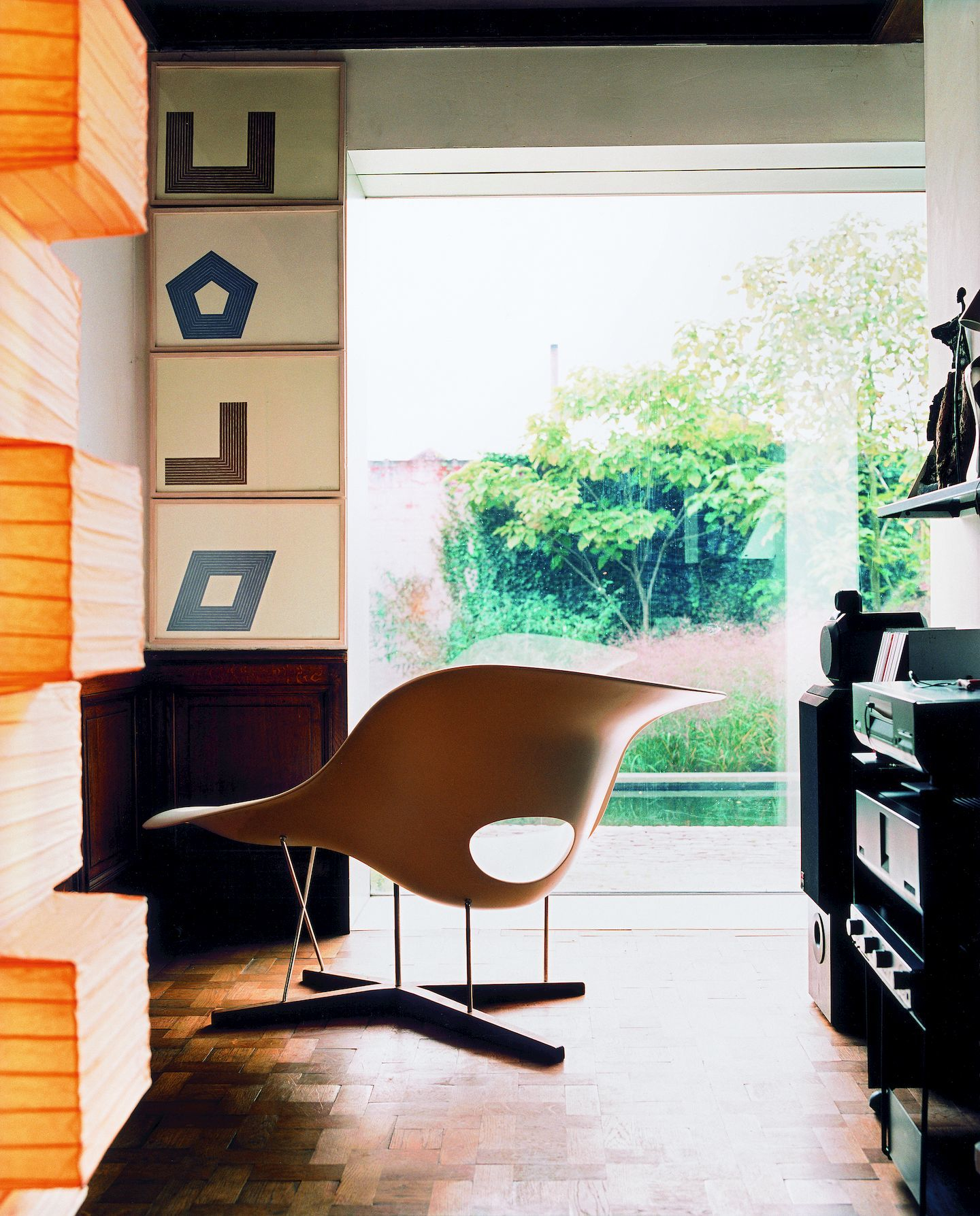 Beige La Chaise Liege Vitra im Wohnzimmer mit großem Fenster und Holzboden.