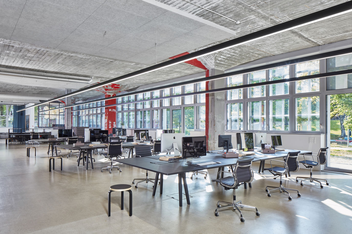 Offenes Büro mit Schreibtischen und Vitra Aluminium Chair EA 119 Bürostühlen mit hoher Rückenlehne.