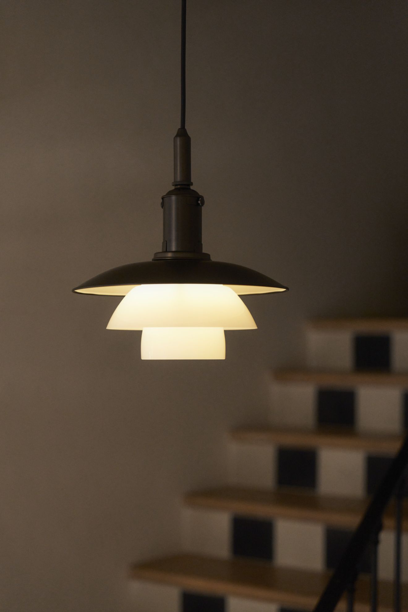 Nahaufnahme der Louis Poulsen PH 3/3 Pendelleuchte aus Messing und Opalglas, modernes skandinavisches Design.