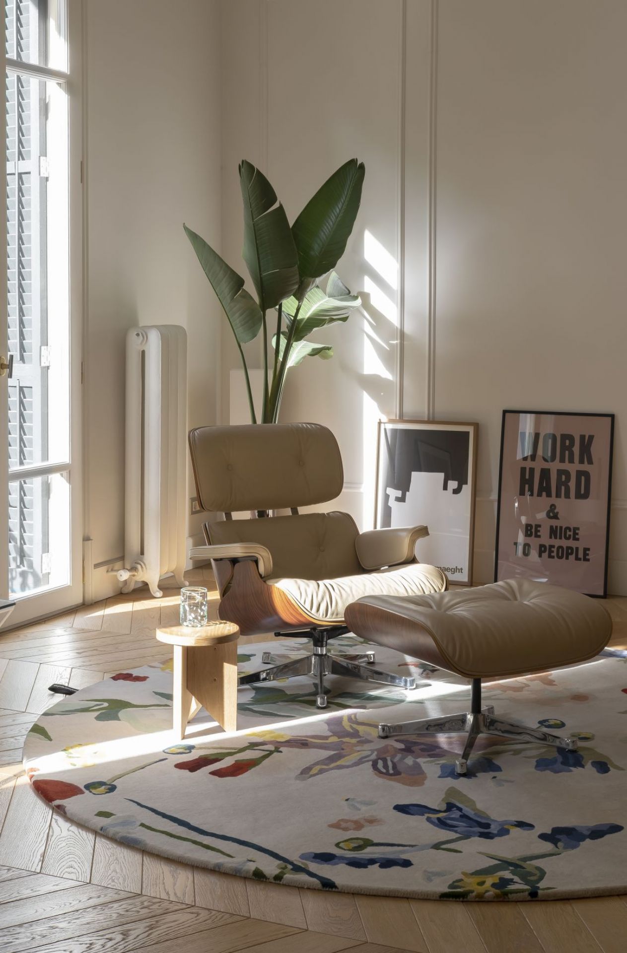 Beiger Ledersessel mit Hocker im modernen Wohnzimmer mit Teppich und Zimmerpflanze. Designermöbel für entspanntes Wohnen.