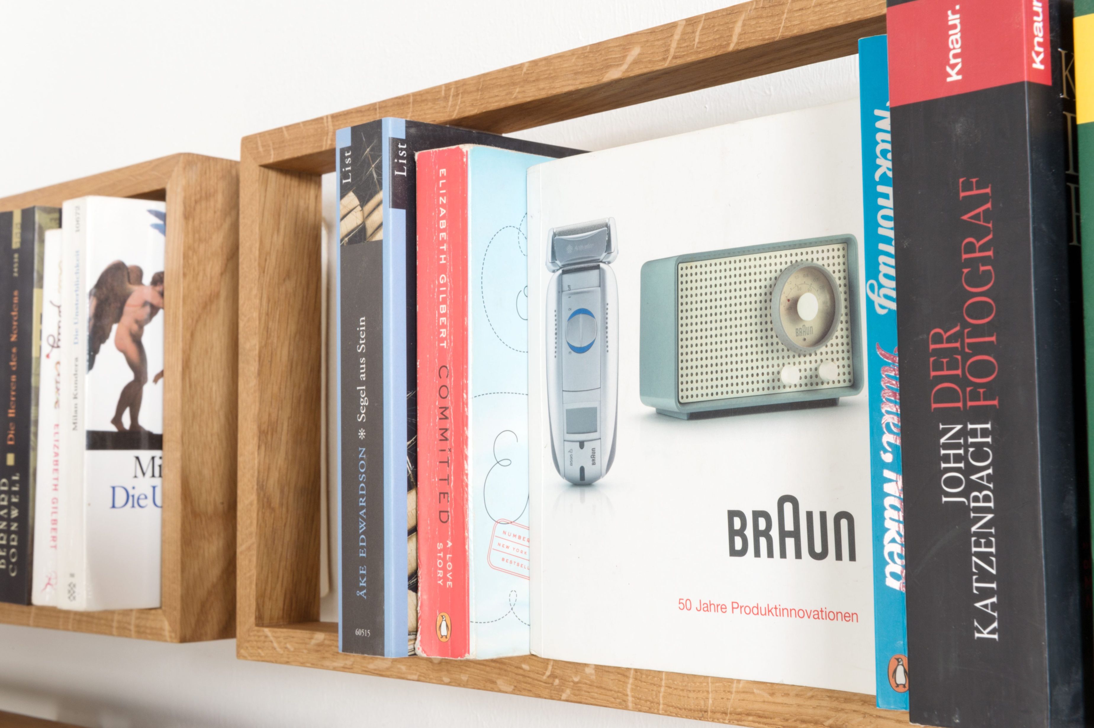 Nahaufnahme des Regal b Eiche das kleine b EINZELSTÜCK, gefüllt mit Büchern und einer Braun-Werbeanzeige.