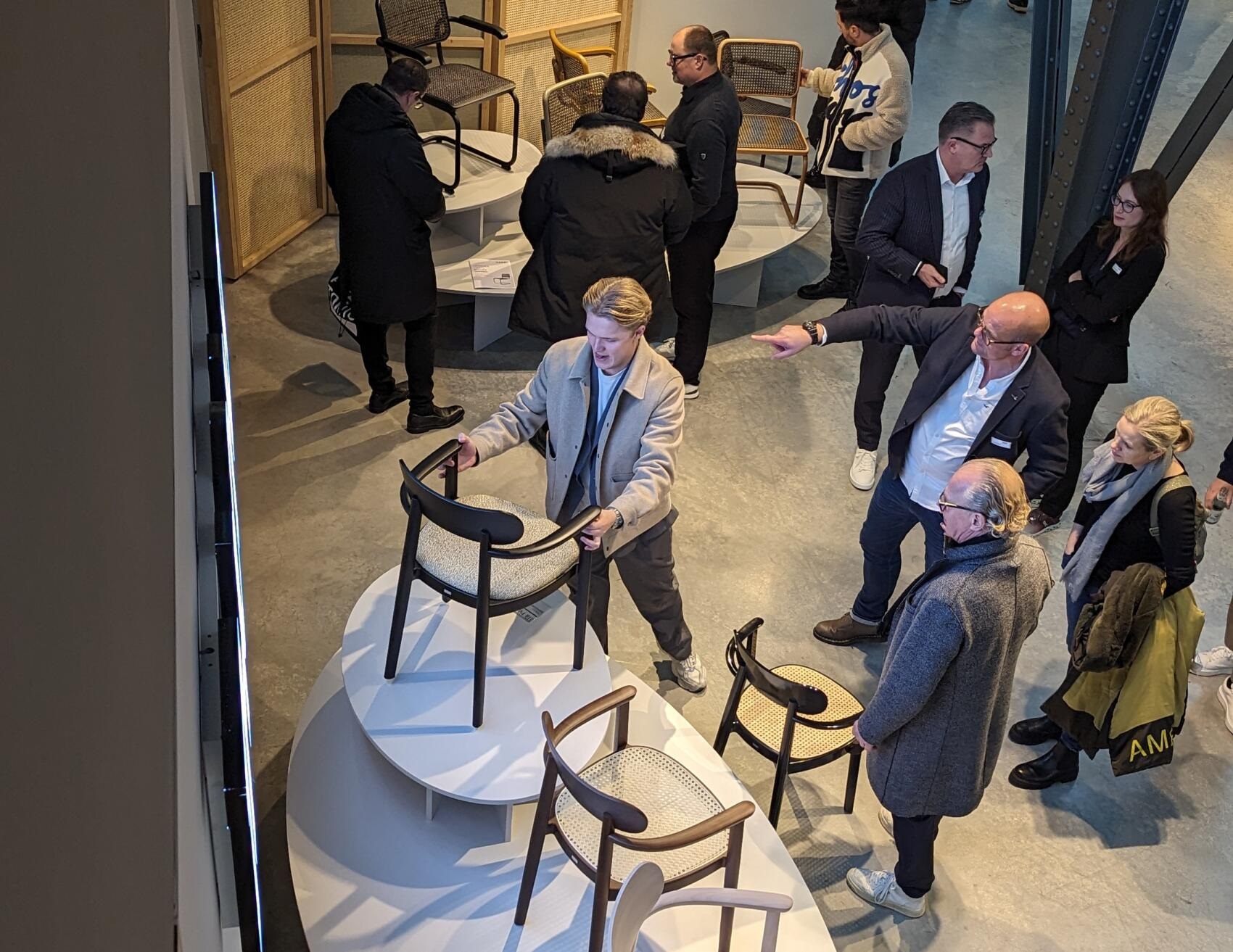 118 SPFV Thonet Holzstuhl mit Armlehnen, schwarzes Gestell und Wiener Geflecht, ausgestellt auf Podest.