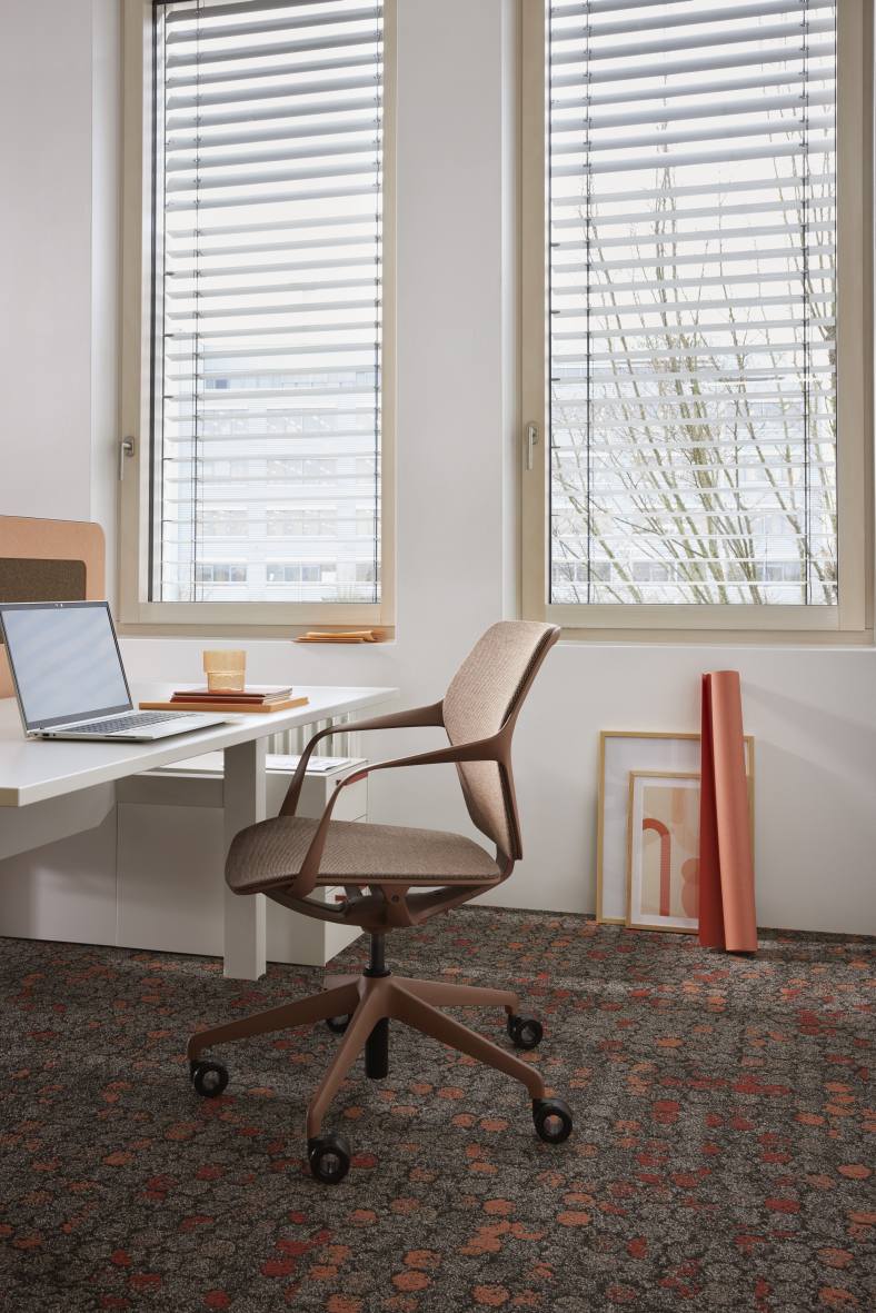 Ray Work 9220 Bürodrehstuhl von Brunner in braun vor Schreibtisch und Fenster mit Jalousien.