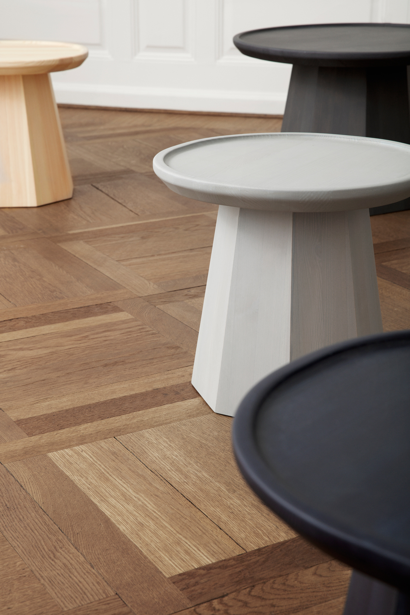 Nahaufnahme von mehreren Pine Table Beistelltischen von Normann Copenhagen in verschiedenen Farben.