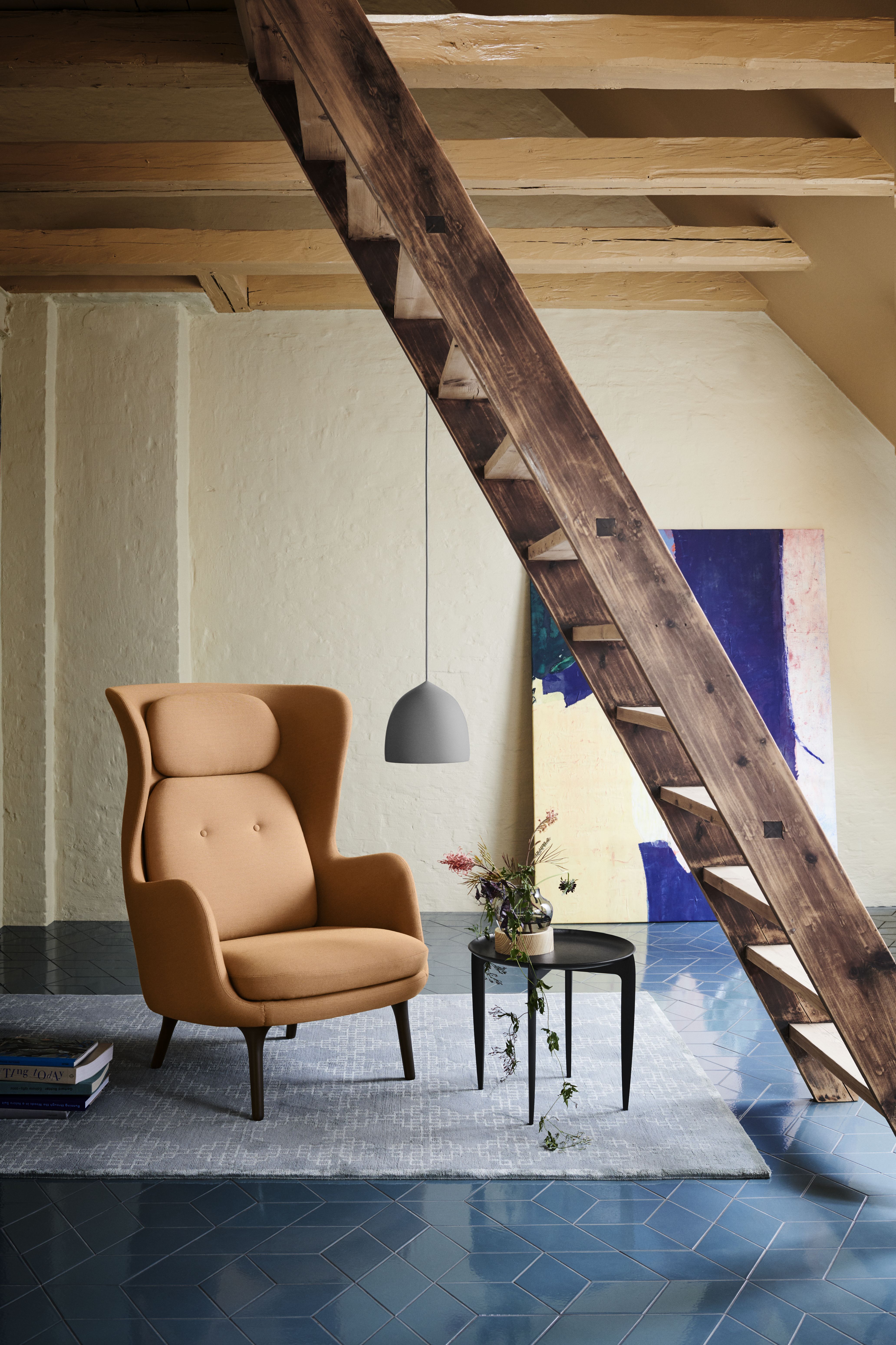 Fritz Hansen Ro Sessel aus Holz, hellbrauner Ohrensessel im Interieur mit Holzbalken und Leiter.