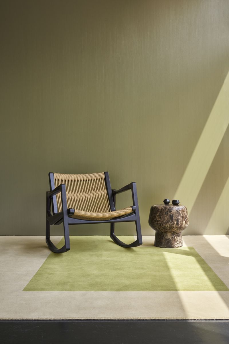 Kilkenny Teppich 300x250cm von ClassiCon in grün-beige unter Schaukelstuhl und Beistelltisch aus Marmor.