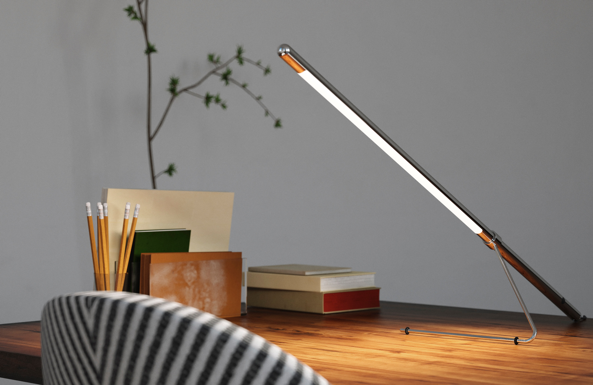 Belux Tubo LED-Tischleuchte auf Schreibtisch mit Büchern, Stiften und Pflanze, modernes Design für Büro und Arbeitszimmer.