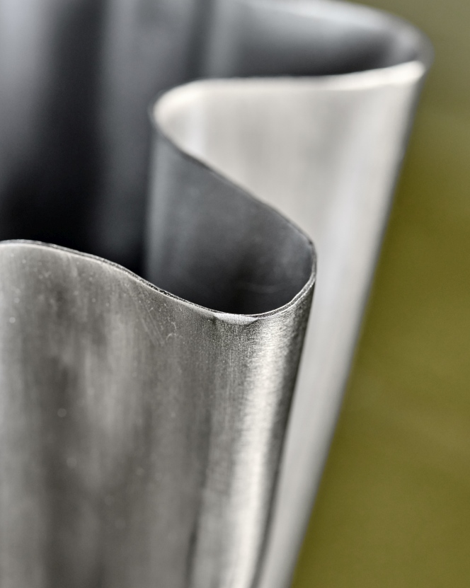 Detailaufnahme der Vase HDFlood von House Doctor mit gebürstetem Silber-Finish und geschwungenem Design.