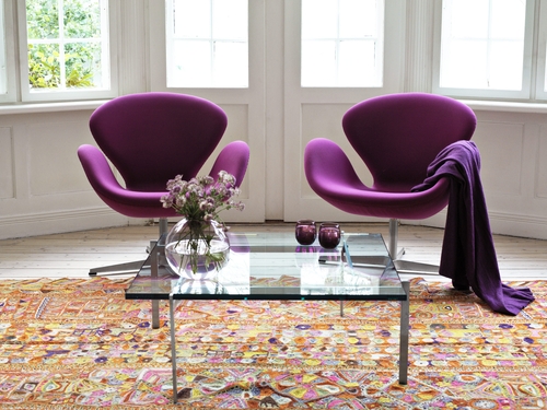 Zwei lila Swan Sessel von Fritz Hansen in einem hellen Wohnzimmer mit Teppich.