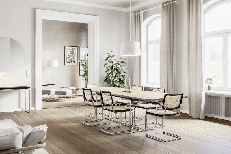 Esszimmer mit Holztisch und sechs Freischwinger Stühlen mit Rattan-Geflecht und Chromgestell.
