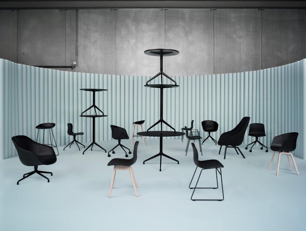 Produktbild: Hay About A Table und Stühle in Schwarz vor hellblauer Wand.