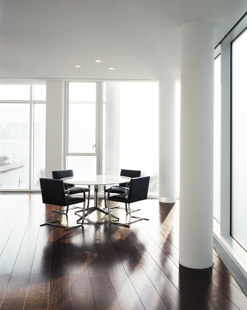 Helle Raumszene mit vier Brno Freischwinger Stühlen und rundem Tisch. Designklassiker von Knoll International.