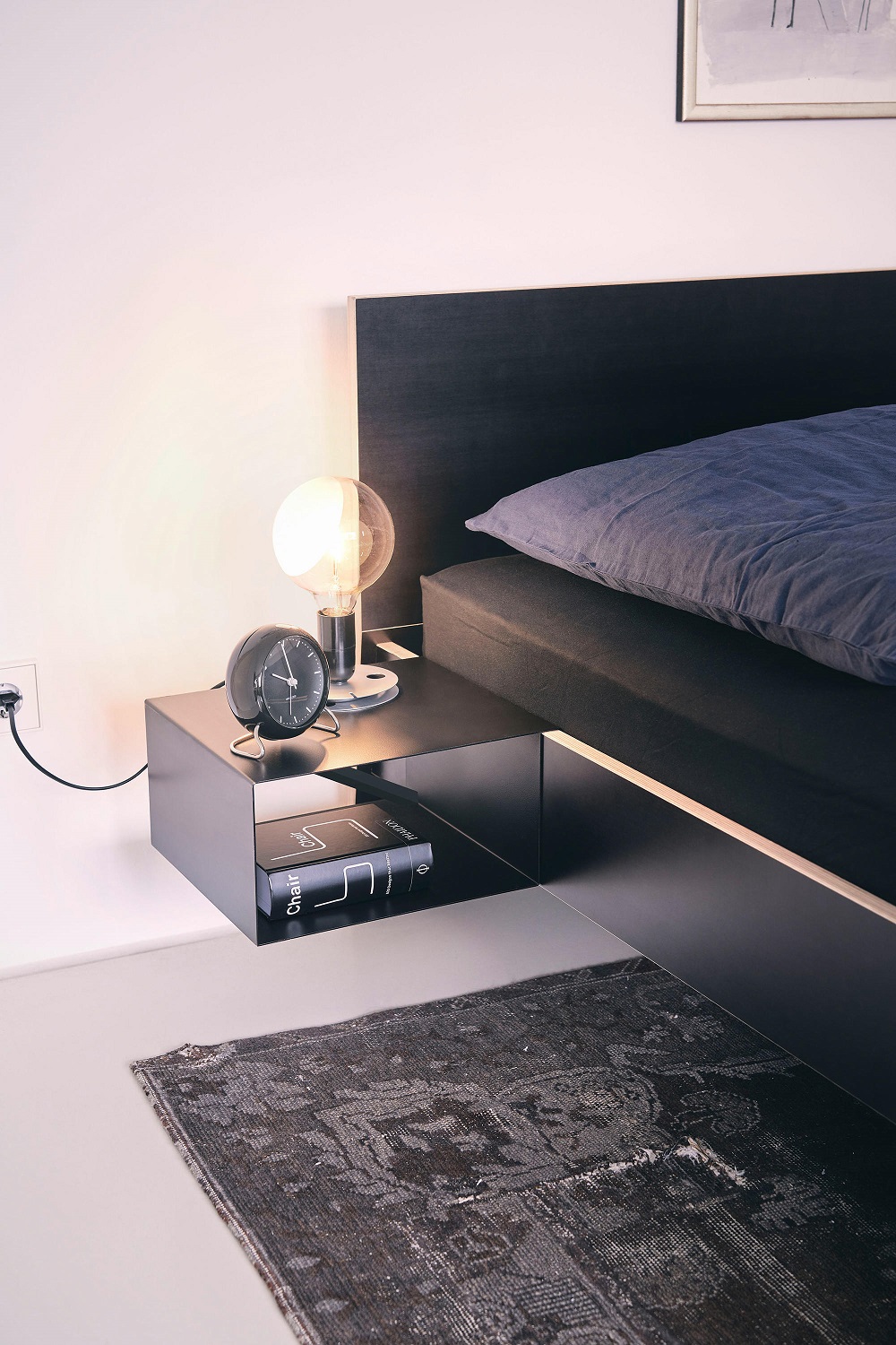 Schwarzer Nachttisch zum Einhängen am Bett mit Lampe und Wecker. Stockholm Bett Nachttisch.