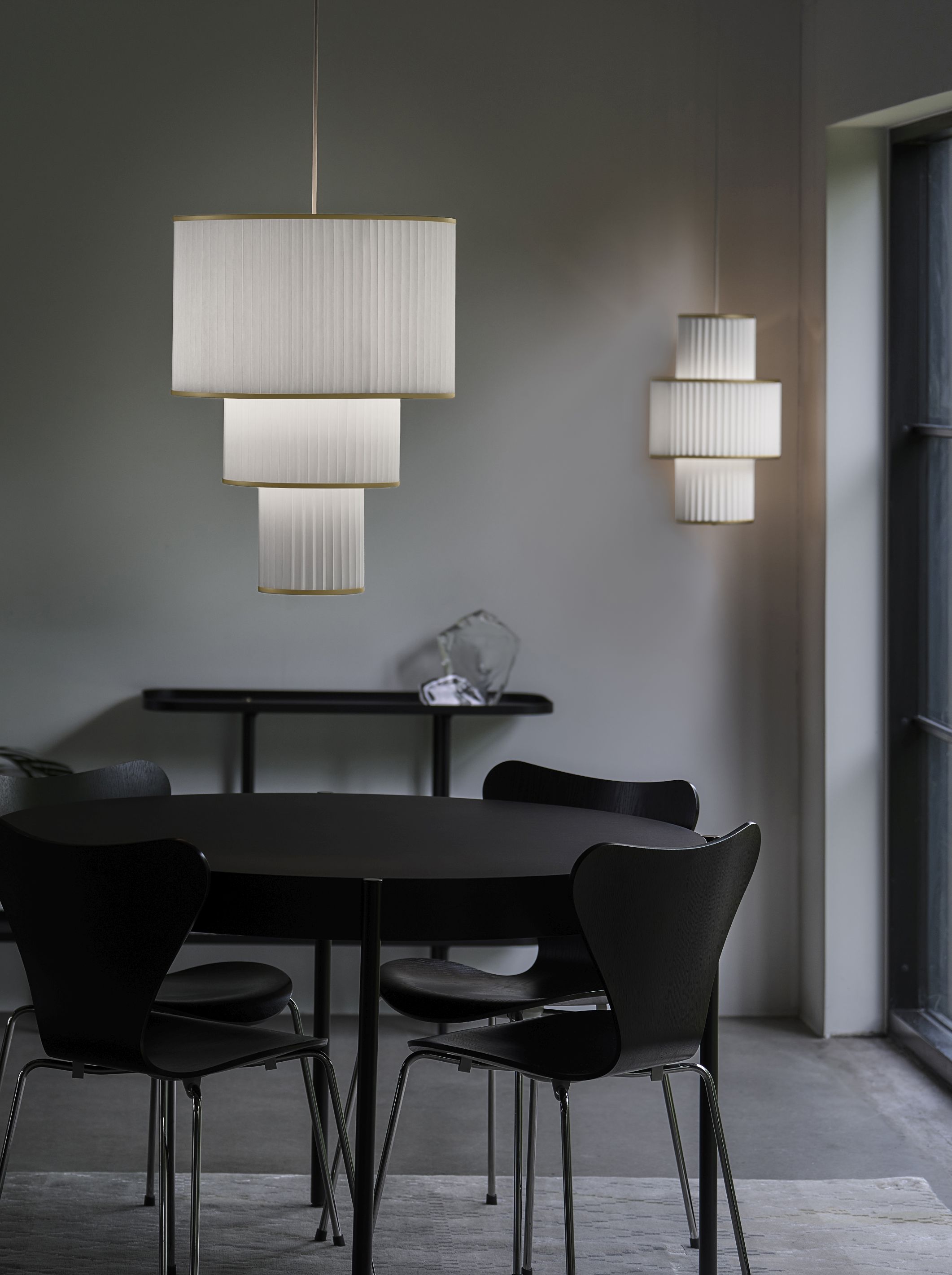 Plivello Pendelleuchte von Le Klint über Esstisch mit Stühlen, moderne Hängeleuchte mit plissiertem Lampenschirm.