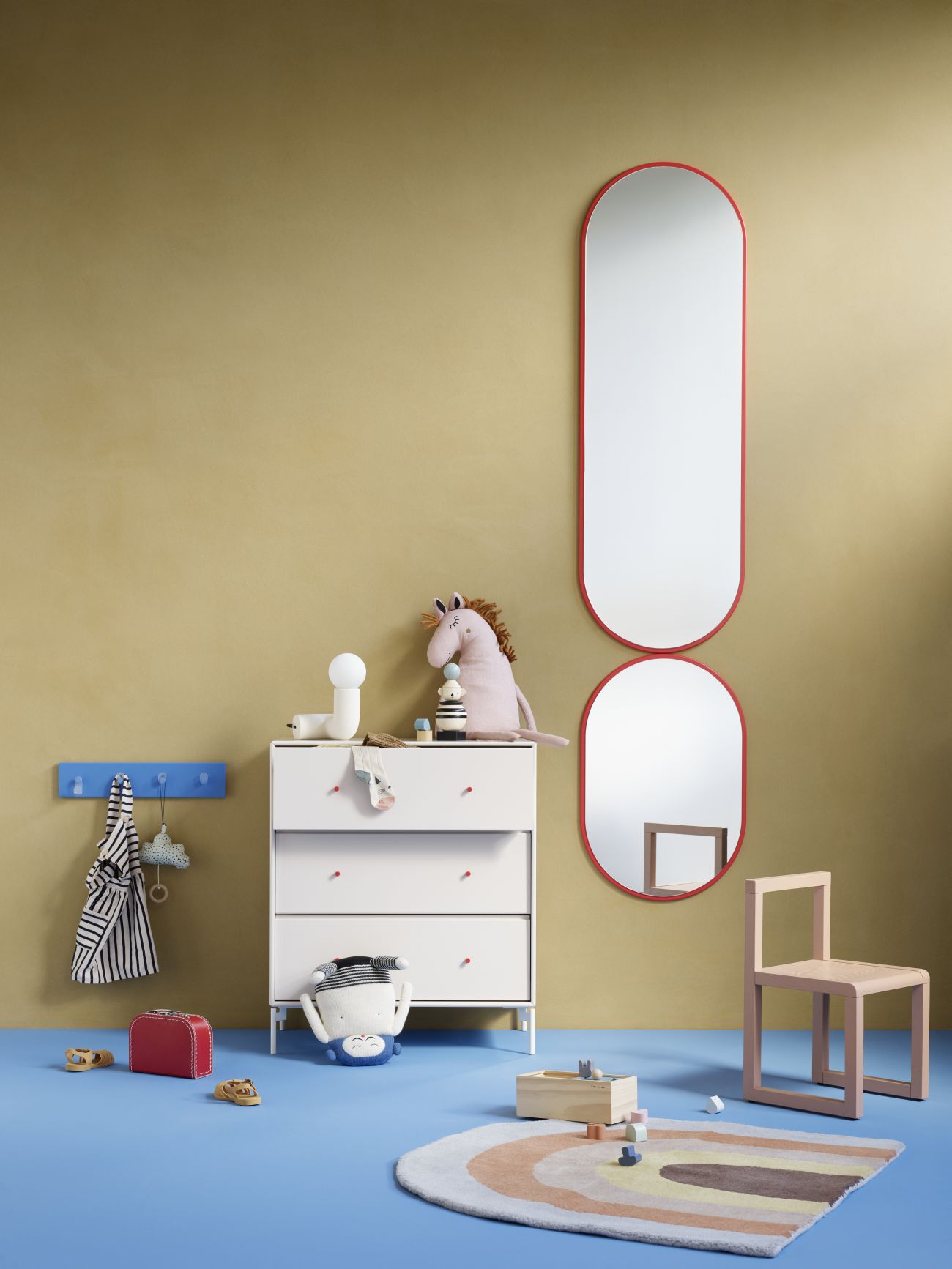 Kinderzimmer mit Colour Frame Spiegel im Look Montana Fjord, rot gerahmt, an goldener Wand.