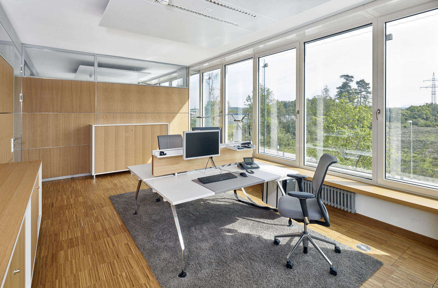 Moderner Büroraum mit Vitra ID Mesh Bürostuhl, Schreibtisch und großem Fenster für optimale Arbeitsatmosphäre.