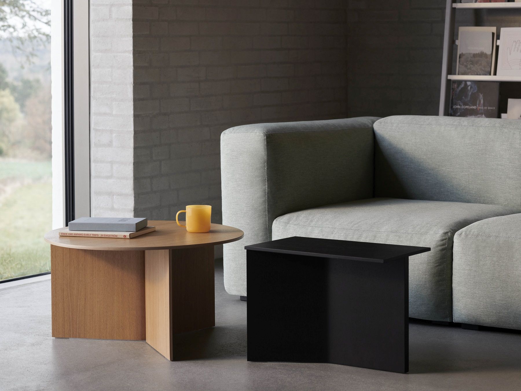 Hay Slit Table Wood Round XL Beistelltisch aus Eichenholz und schwarzer Slit Table als Couchtisch.