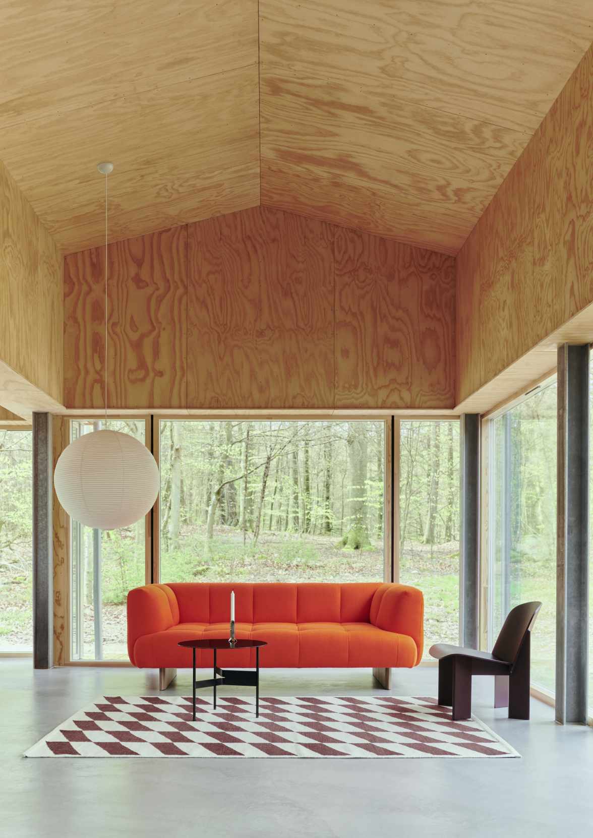 Oranges Quilton Sofa von Hay, ein modernes 2-Sitzer Sofa im Wohnzimmer mit Teppich und Stuhl.