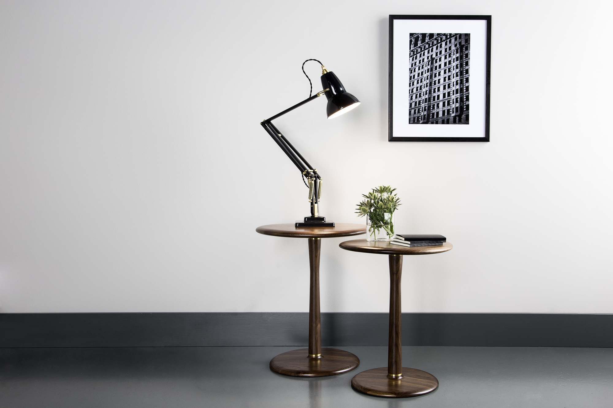 Anglepoise Original 1227 Messing Tischleuchte auf einem Holzbeistelltisch, modernes Wohnambiente mit Kunstwerk.