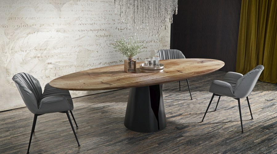Mono Tisch Trebord: Ovaler Esstisch aus Holz mit schwarzem Sockel und grauen Stühlen.