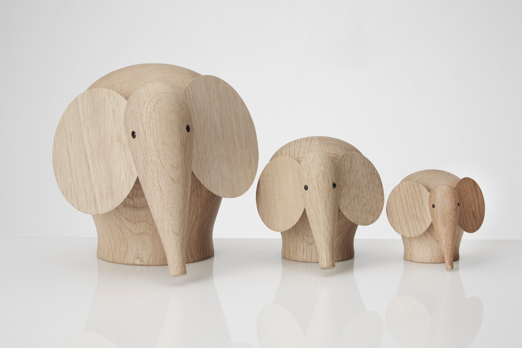 Drei Nunu Holzelefanten in verschiedenen Größen, dekorative Holzfiguren für Kinderzimmer und Wohnraum.