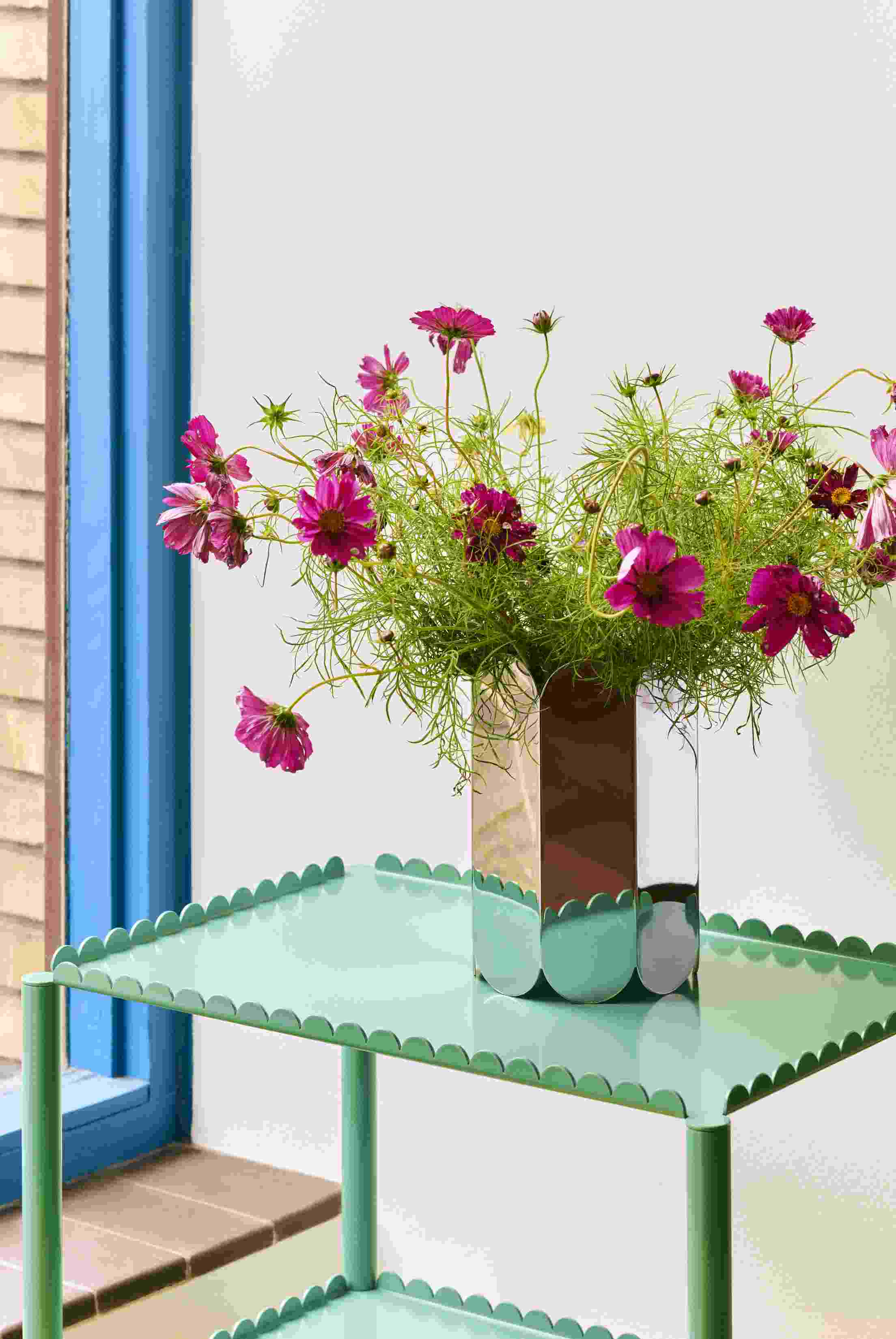 Arcs Vase L Mirror von Hay mit Blumen auf einem mintgrünen Tisch.
