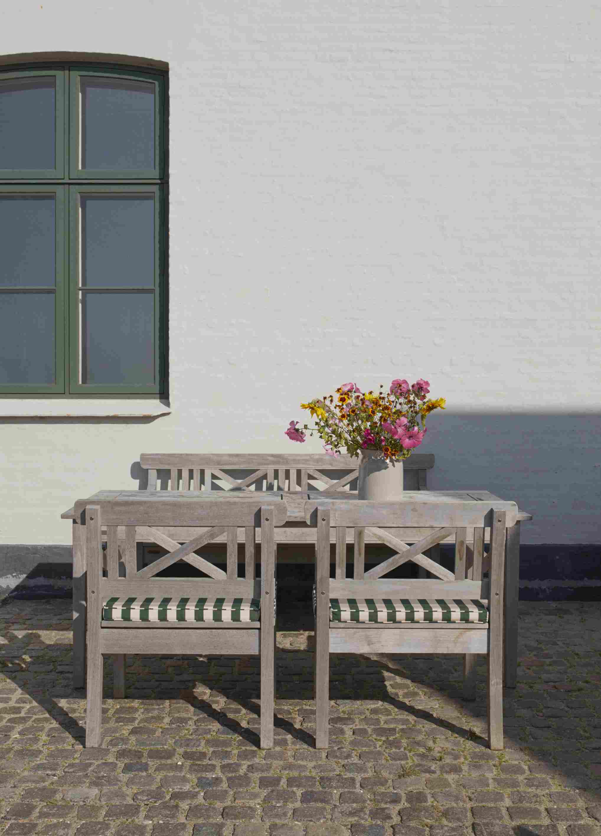 Drachmann Stuhl mit Zitrone/Sand gestreiftem Sitzkissen von Skagerak by Fritz Hansen im Outdoor-Bereich.