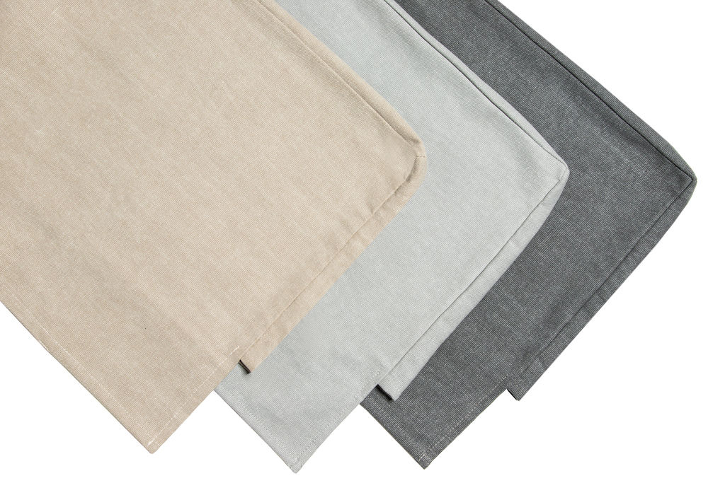 Nahaufnahme von drei Stoffmustern für Hans Hansen Pure Bett Kopfteil Bezug in Beige, Grau und Anthrazit.
