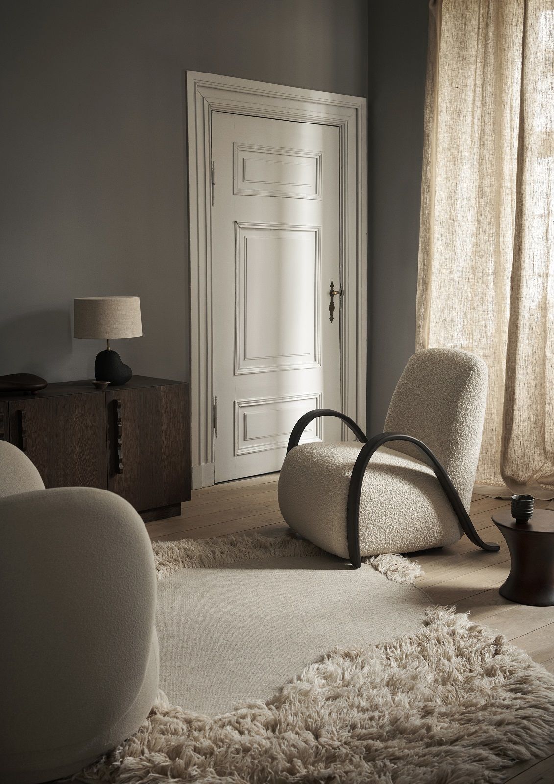 Beige Buur Lounge Chair von Ferm Living mit schwarzen Armlehnen in einem stilvollen Wohnzimmer.