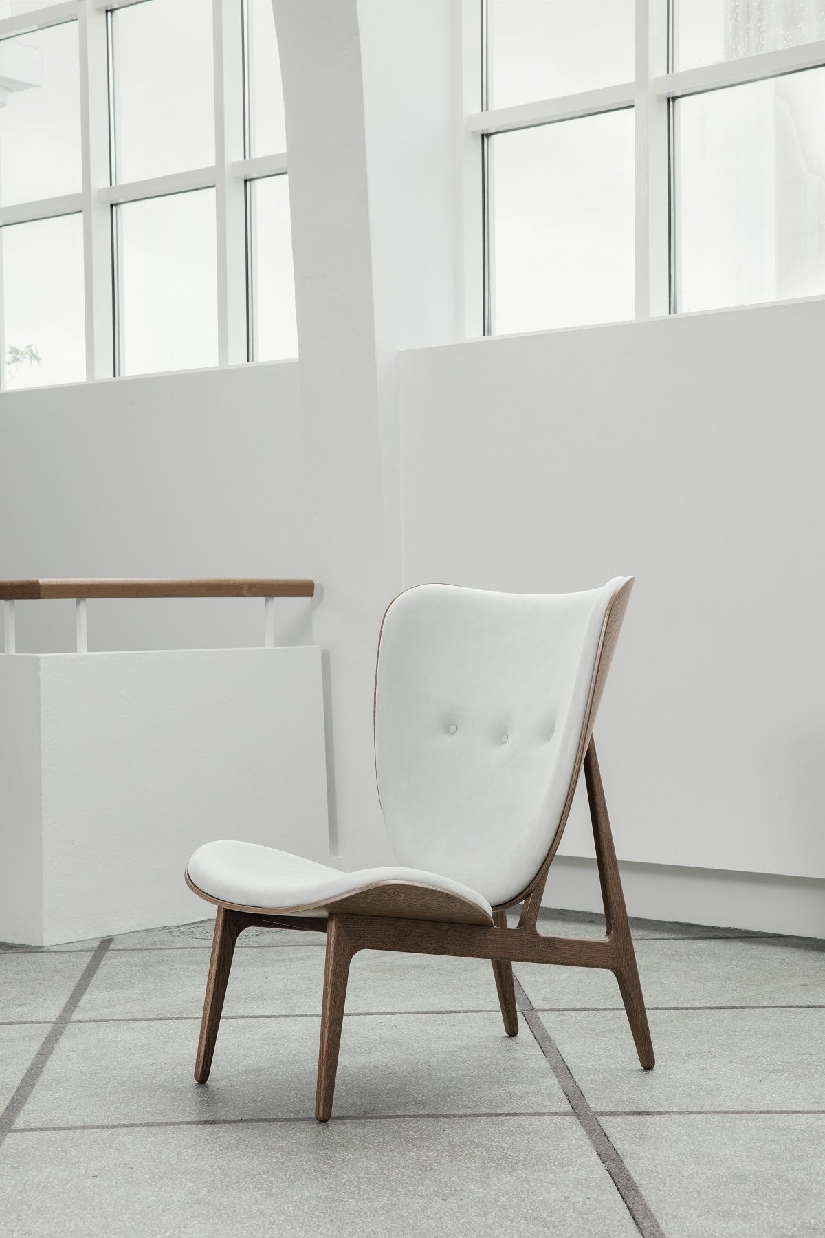 NORR11 Elephant Lounge Chair Sessel mit weißem Stoffbezug und Holzgestell vor hellem Hintergrund.