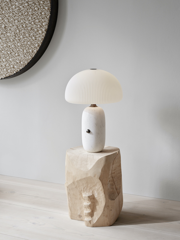 Nahaufnahme der Vipp Sculpture Tischlampe mit plissiertem Schirm auf einem geschnitzten Holzsockel.