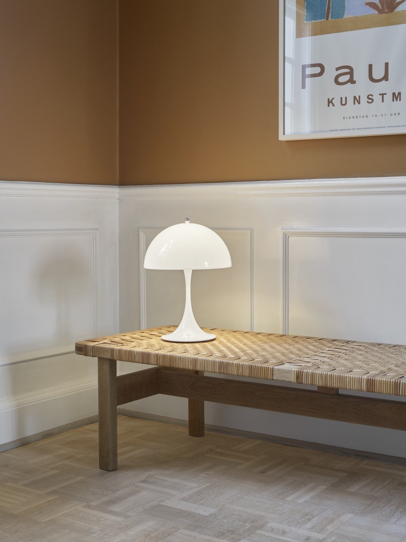 Nahaufnahme der Panthella 250 Portable LED-Tischleuchte von Louis Poulsen in Opalweiß auf Bank.