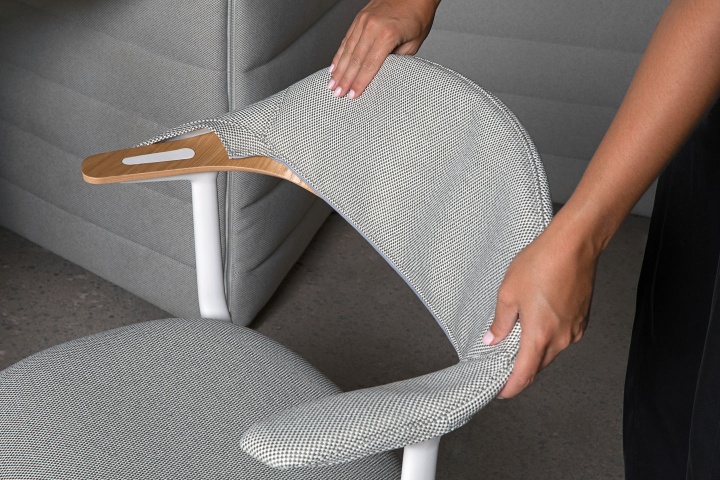 Detailaufnahme des Mynt Bürodrehstuhls von Vitra mit grauem Stoffbezug und hellen Holzarmlehnen.