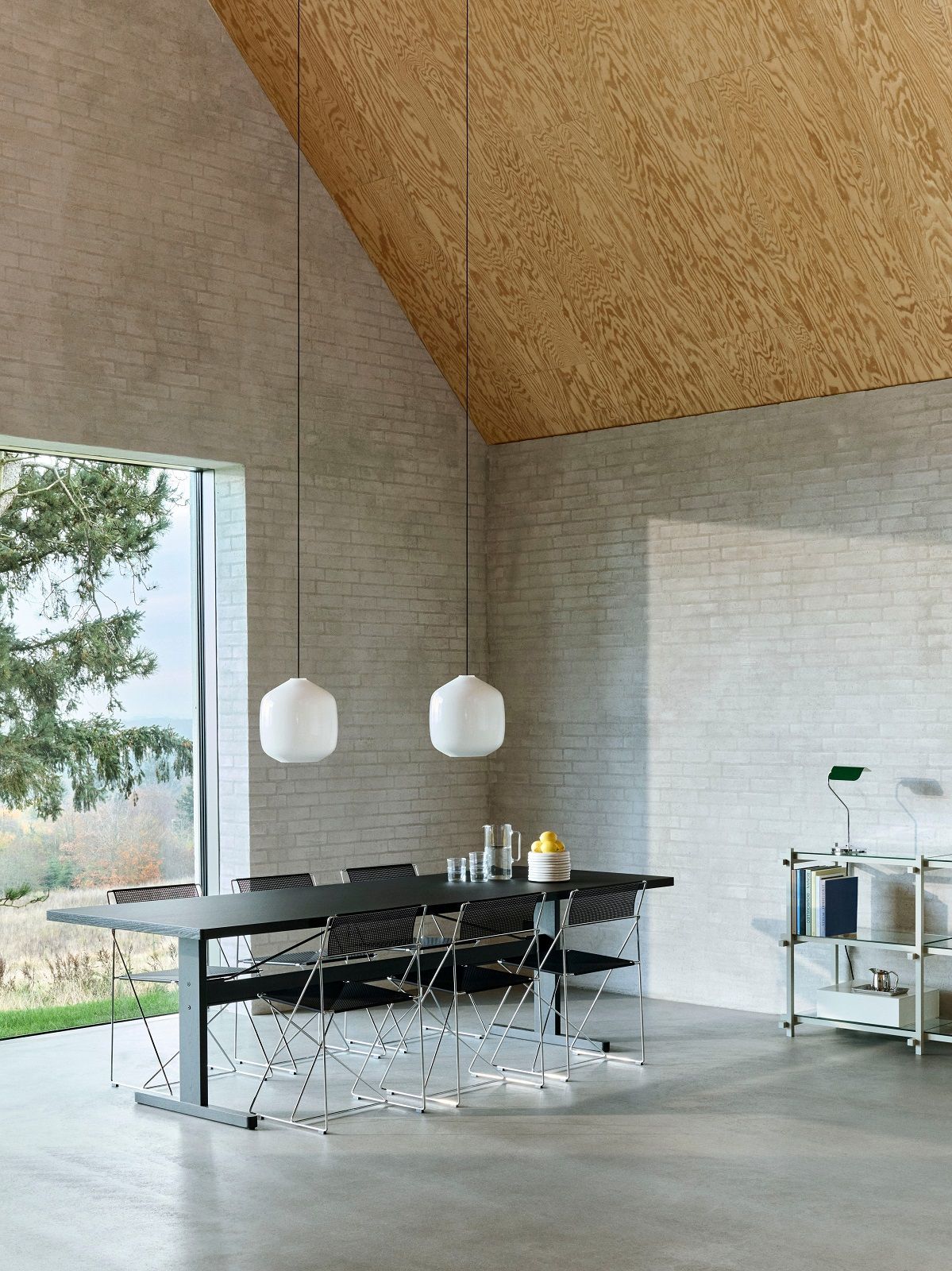 Zwei weiße Hay Pendelleuchten Aspekt Buoy über einem Esstisch in einem modernen Interieur.