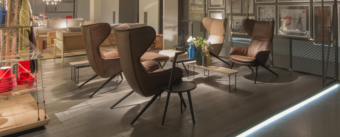 Braune 395 P22 Sessel von Cassina im modernen Wohnzimmer, Ledersessel mit hoher Rückenlehne und Beistelltischen.