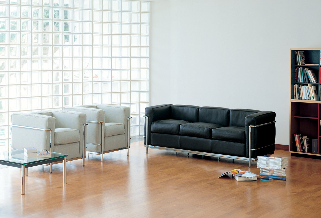 Zwei Cassina Grand Confort Sessel und ein Sofa mit Stahlrohrgestell in einem Wohnraum.
