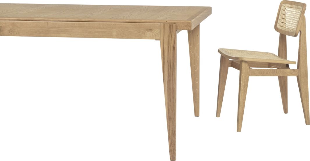 Gubi S-Table Esstisch ausziehbar aus hellem Holz mit passendem Stuhl mit Rattangeflecht.