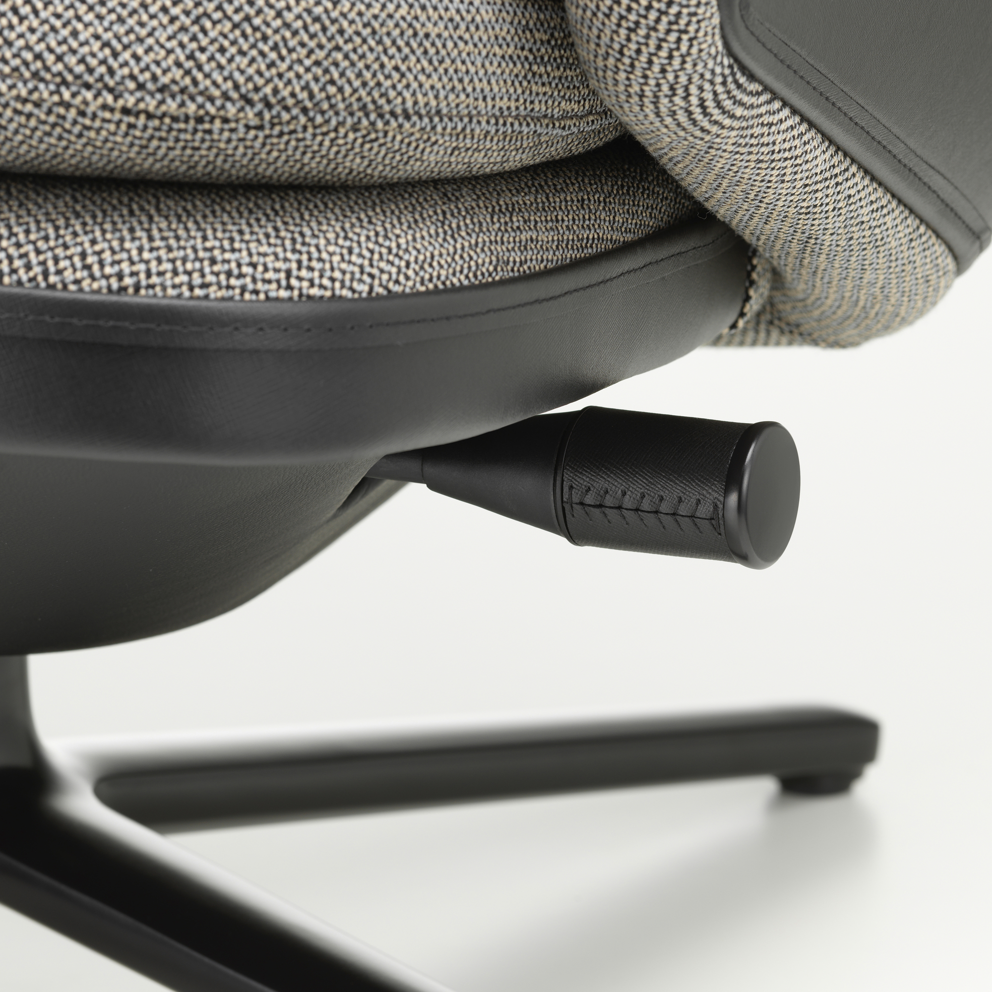 Detailaufnahme des Vitra Grand Relax Sessels: Verstellhebel, Stoffbezug und schwarzes Untergestell.