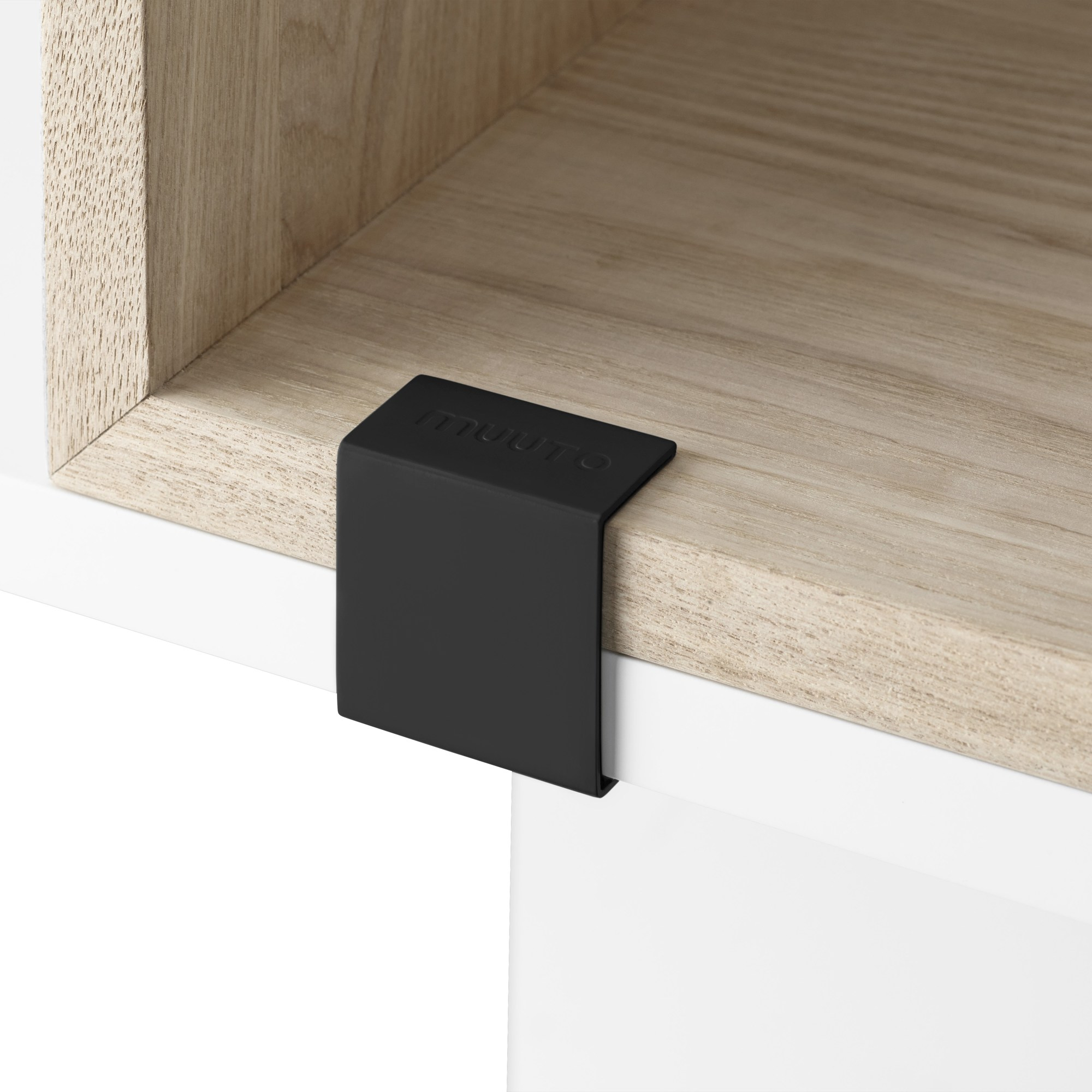 Detailaufnahme des Muuto Stacked Storage System 2.0 Regalsystems mit schwarzer Verbindungsspange und hellem Holzregal.